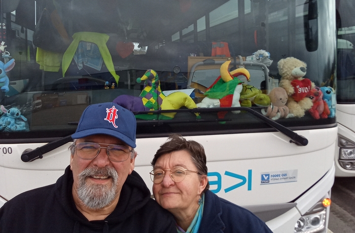 Tortelduifjes Alain en Véronique bij hun schoolbus, versierd met een groot hart en knuffels