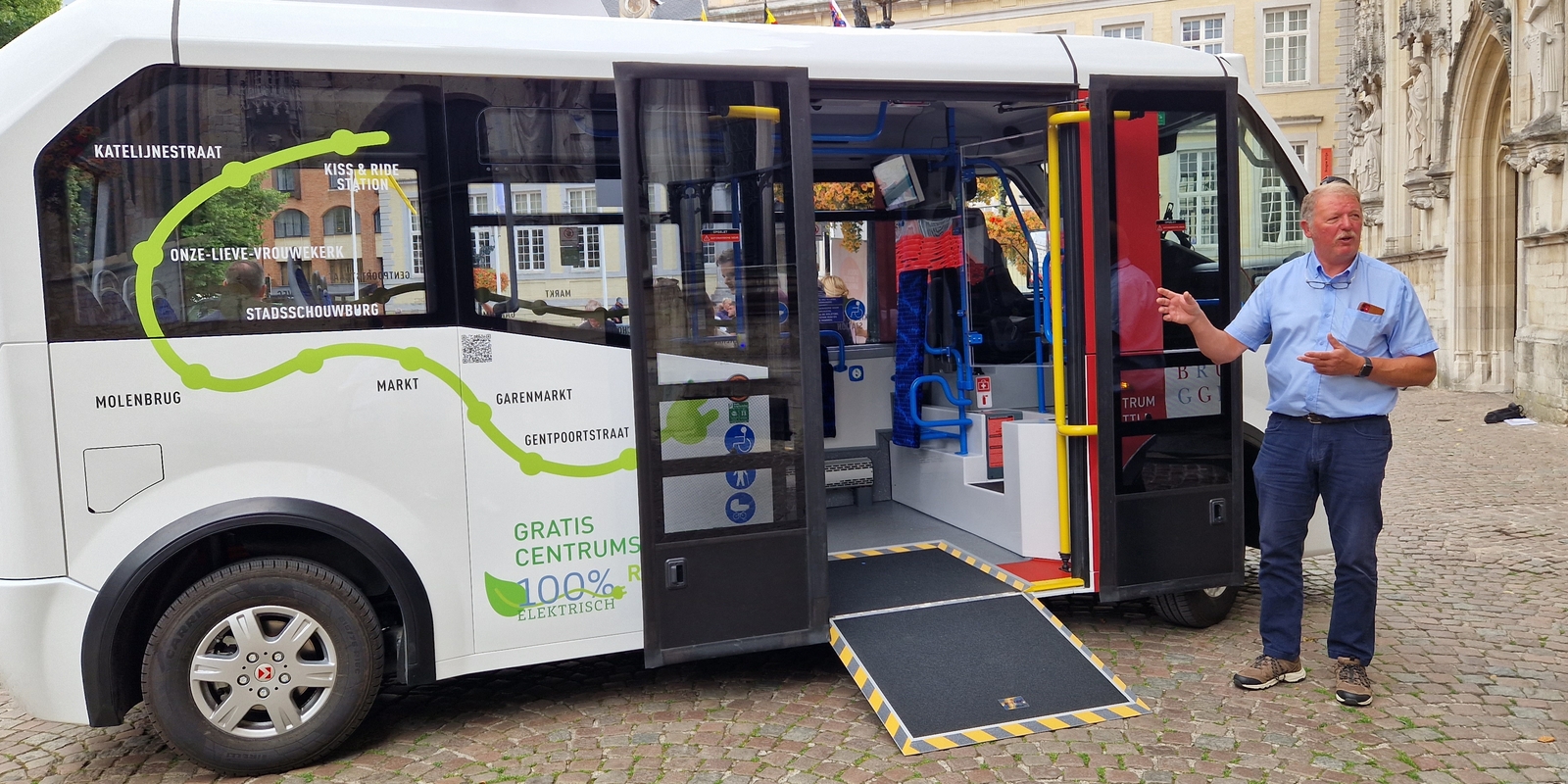 Chauffeur Wilfried toont de elektrische bus, met oprijplaat voor minder mobiele mensen