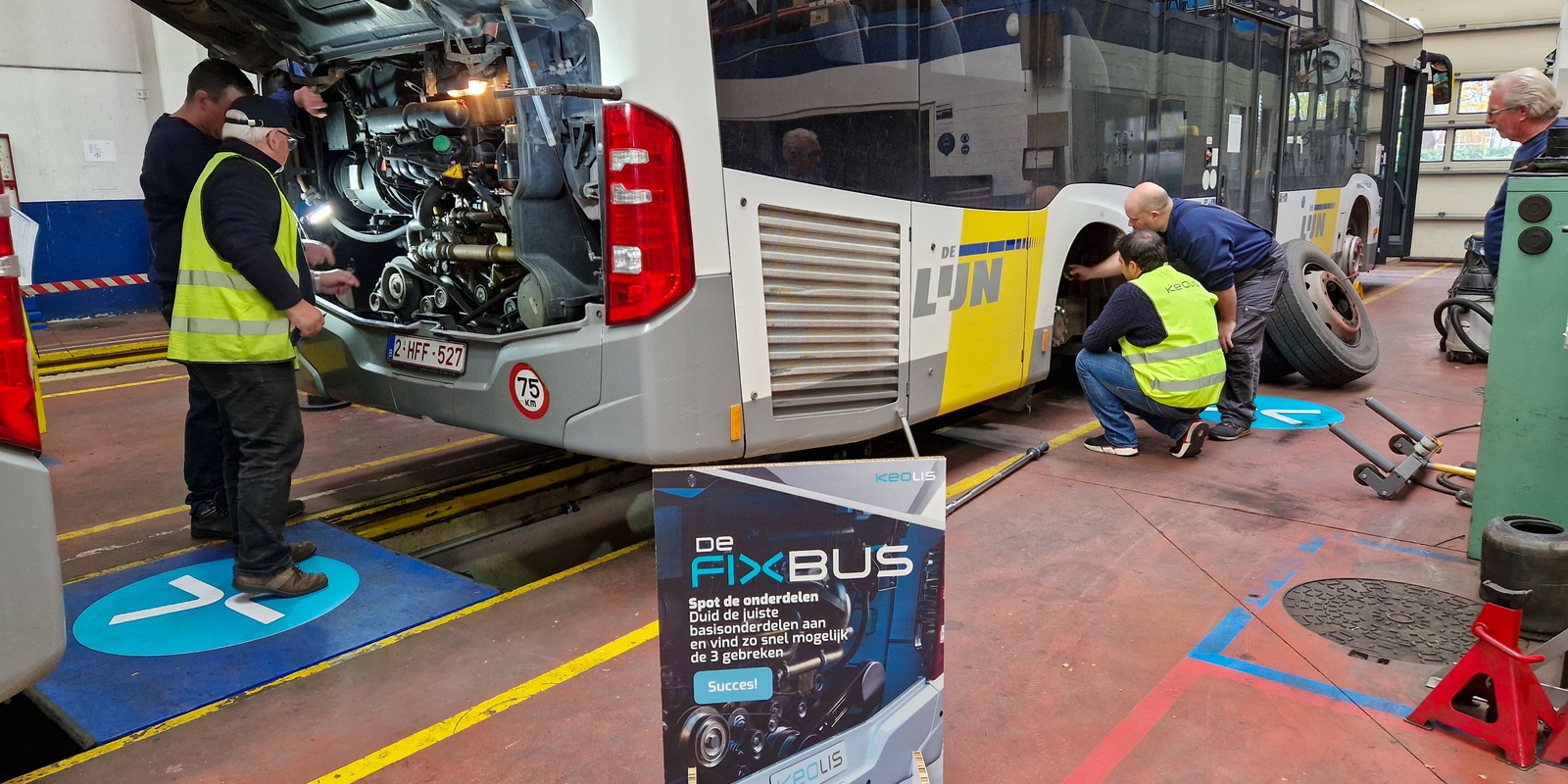 Twee mecaniciens tonen enkele opdrachten aan kandidaten.