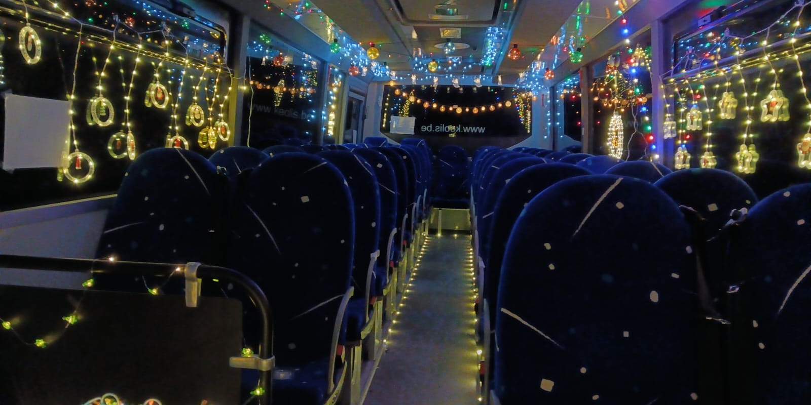 Versierde kerstbus met lichtslingers en kerstdecoraties